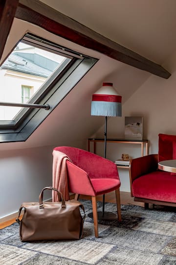 a room with a red couch and a lamp