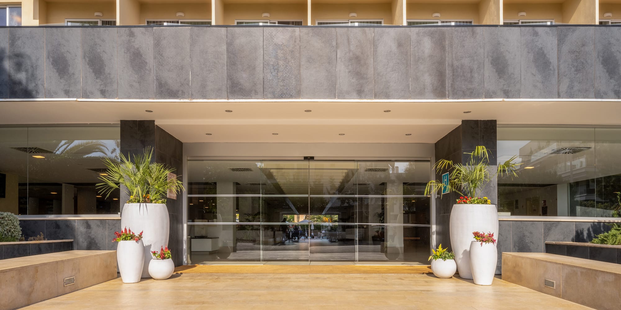 a building with glass doors and plants