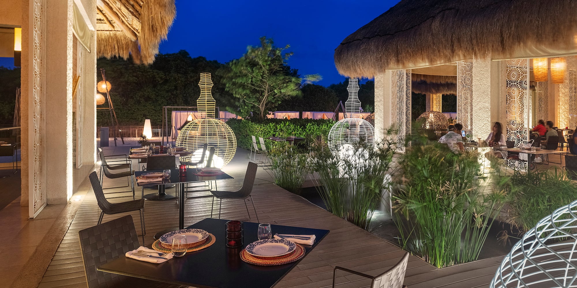 a restaurant with a thatched roof and tables and chairs