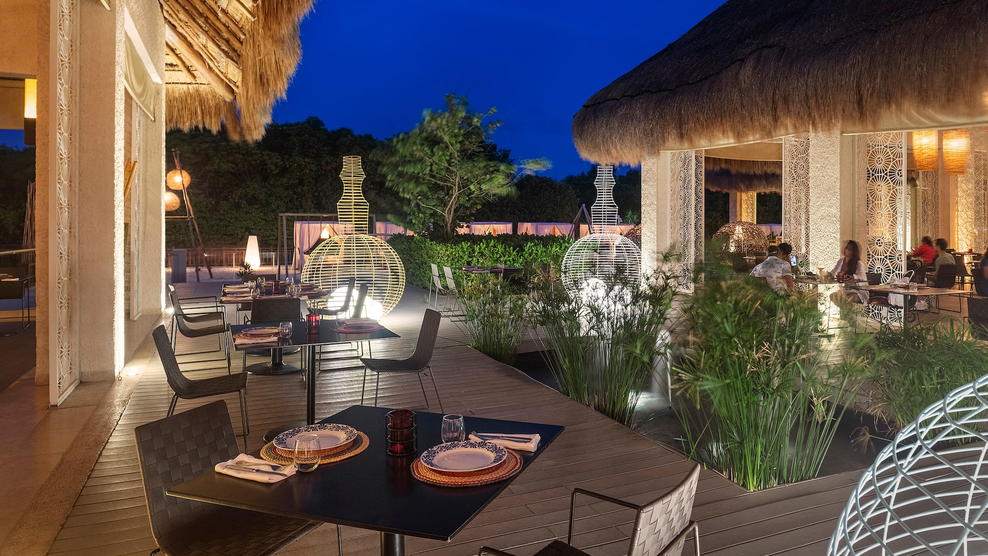 a restaurant with a thatched roof and tables and chairs