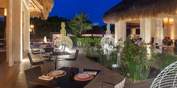 a restaurant with a thatched roof and tables and chairs