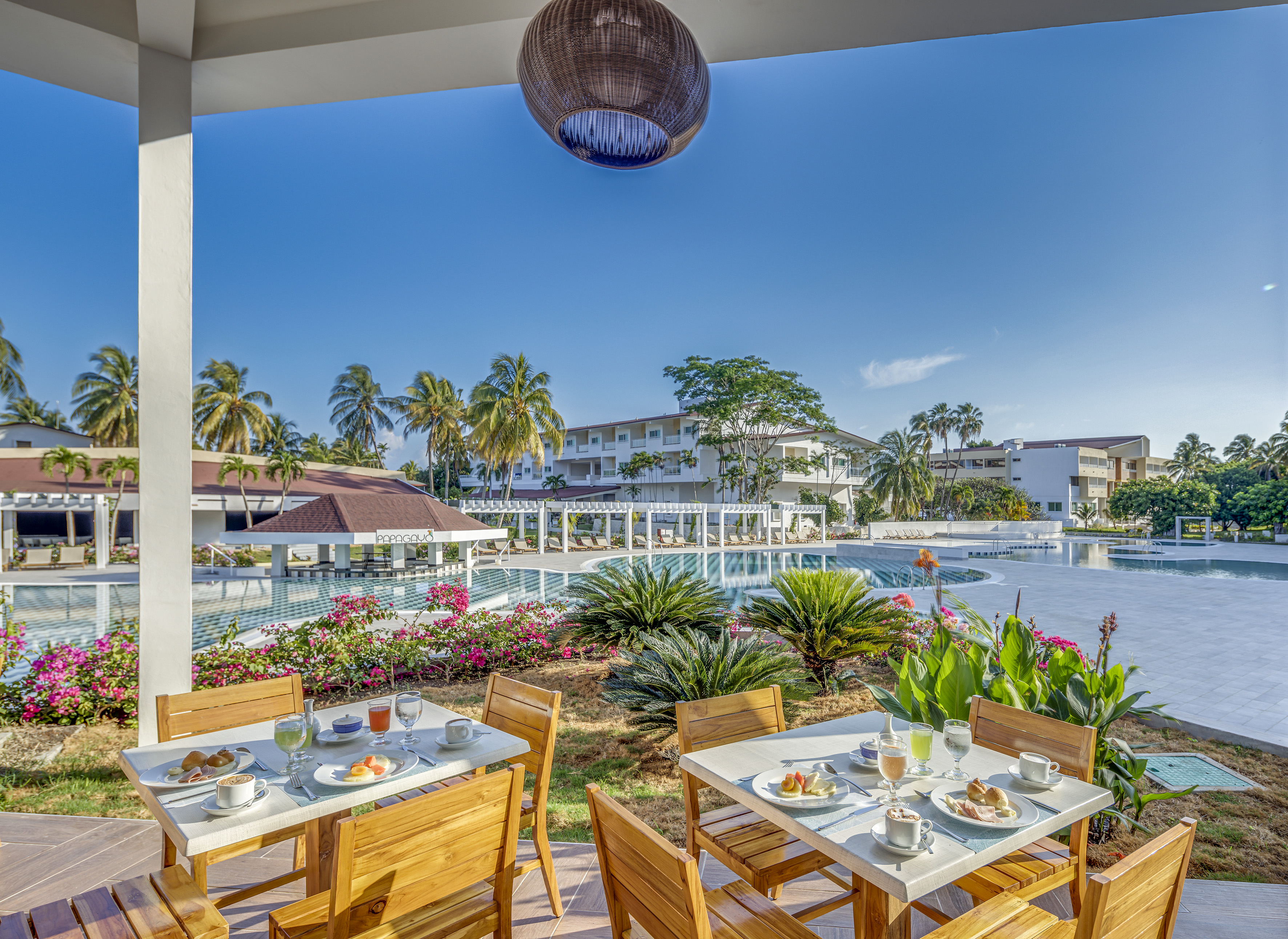 a table and chairs with food on it by a pool