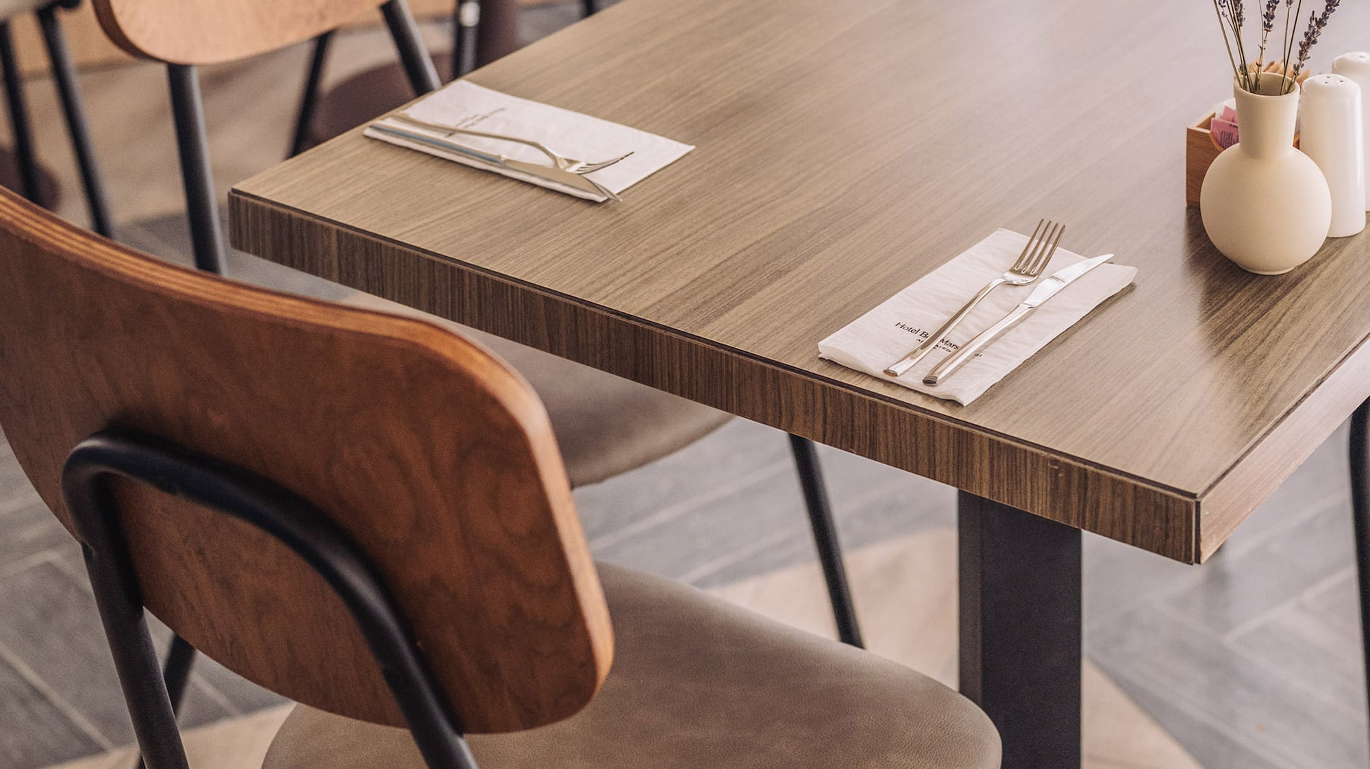 a table with chairs and a vase of flowers