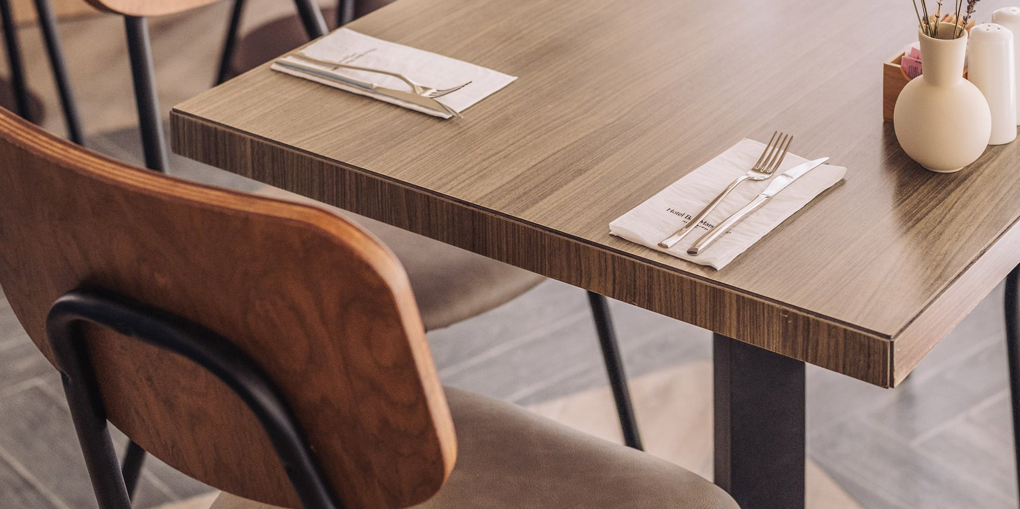 a table with chairs and a vase of flowers