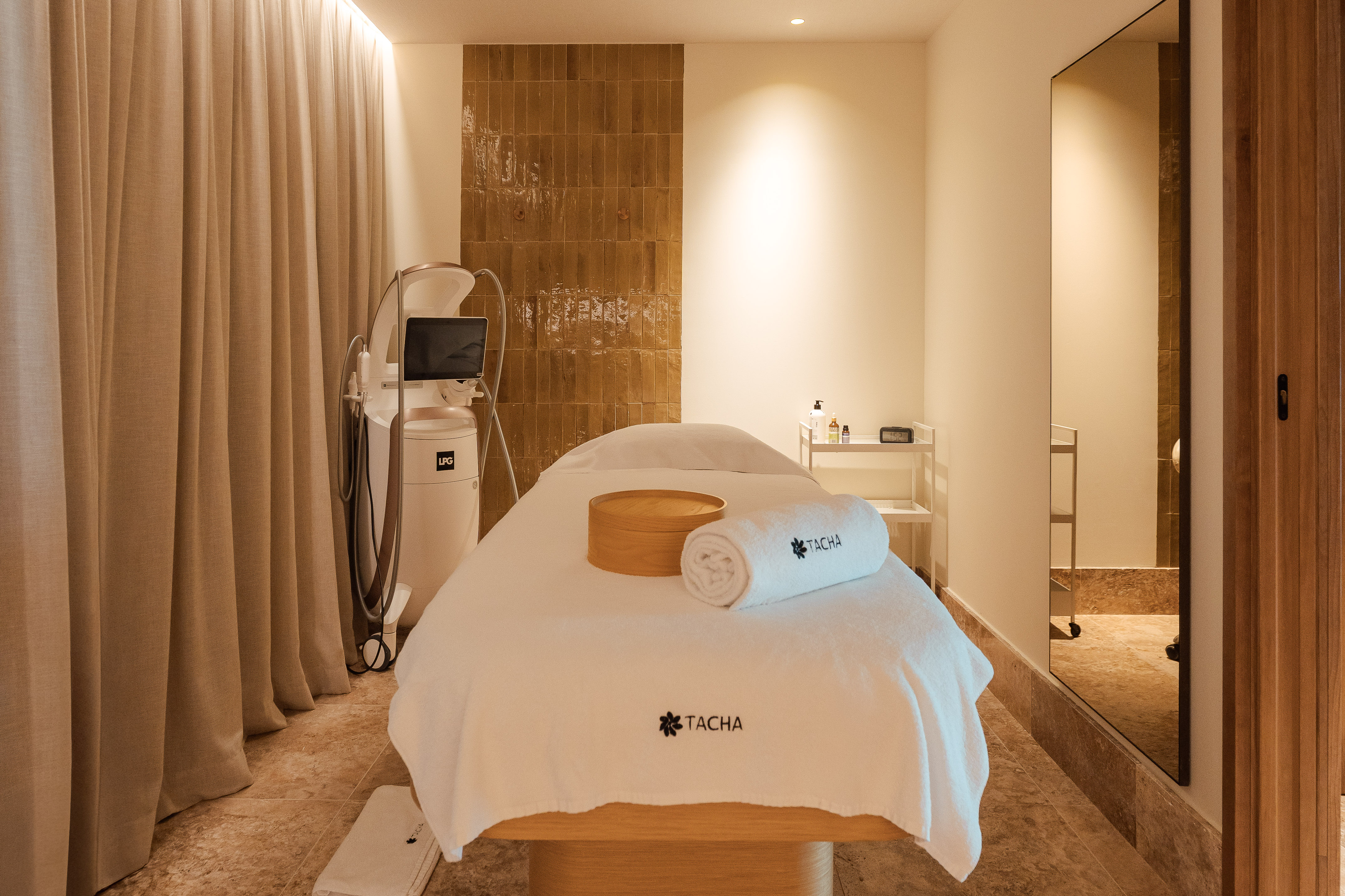 Modern spa treatment room with LPG machine, TACHA bed, and neutral decor.
