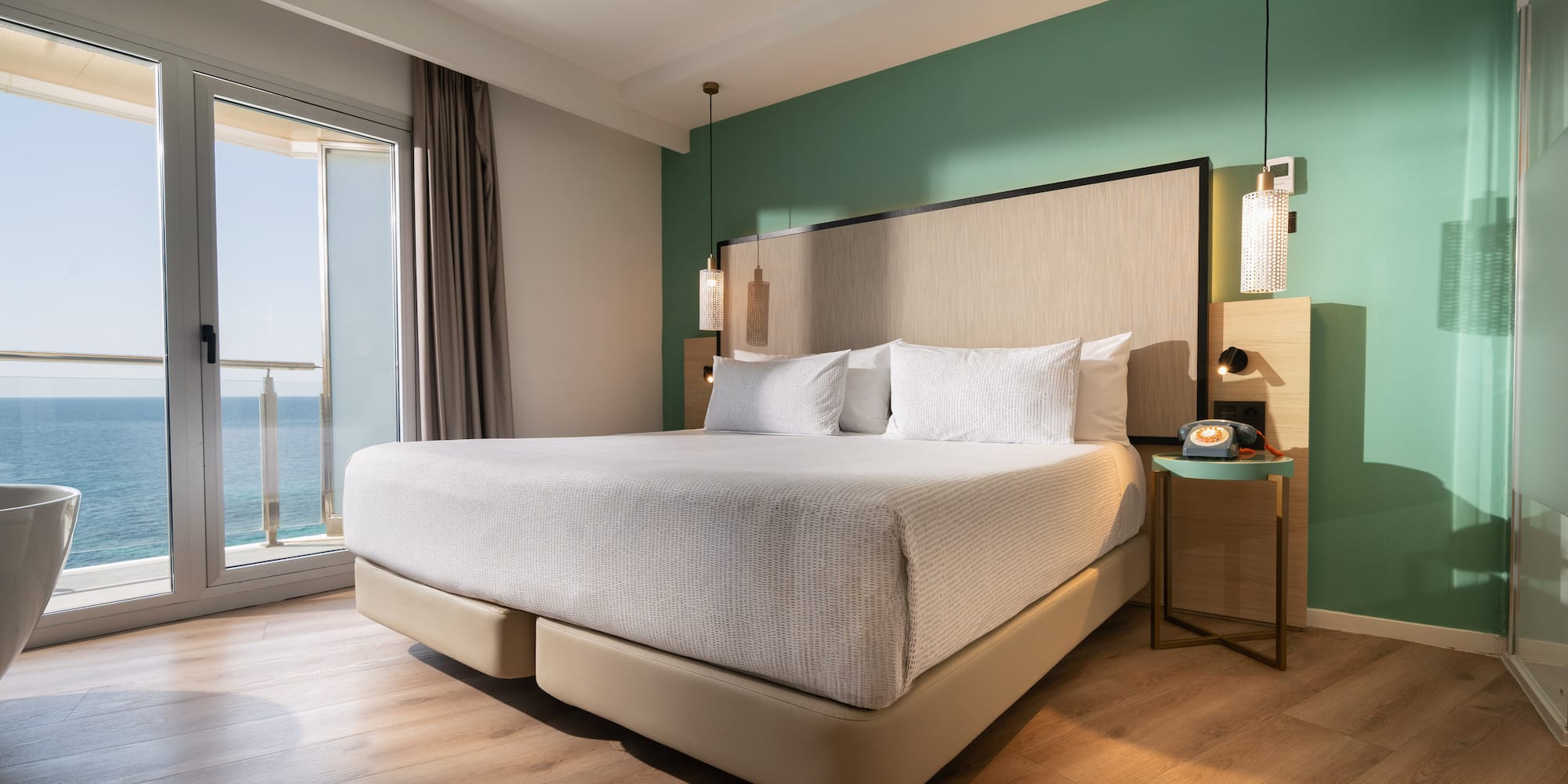 a bed with a large headboard and a glass door