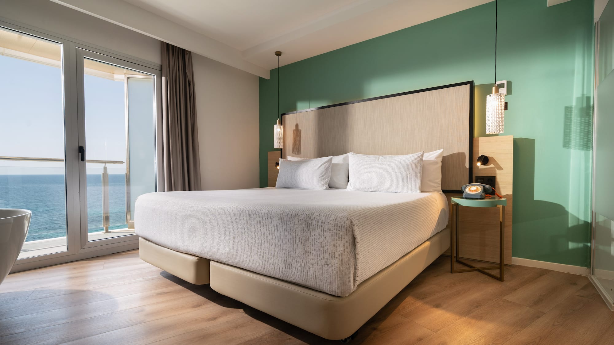 a bed with a large headboard and a glass door