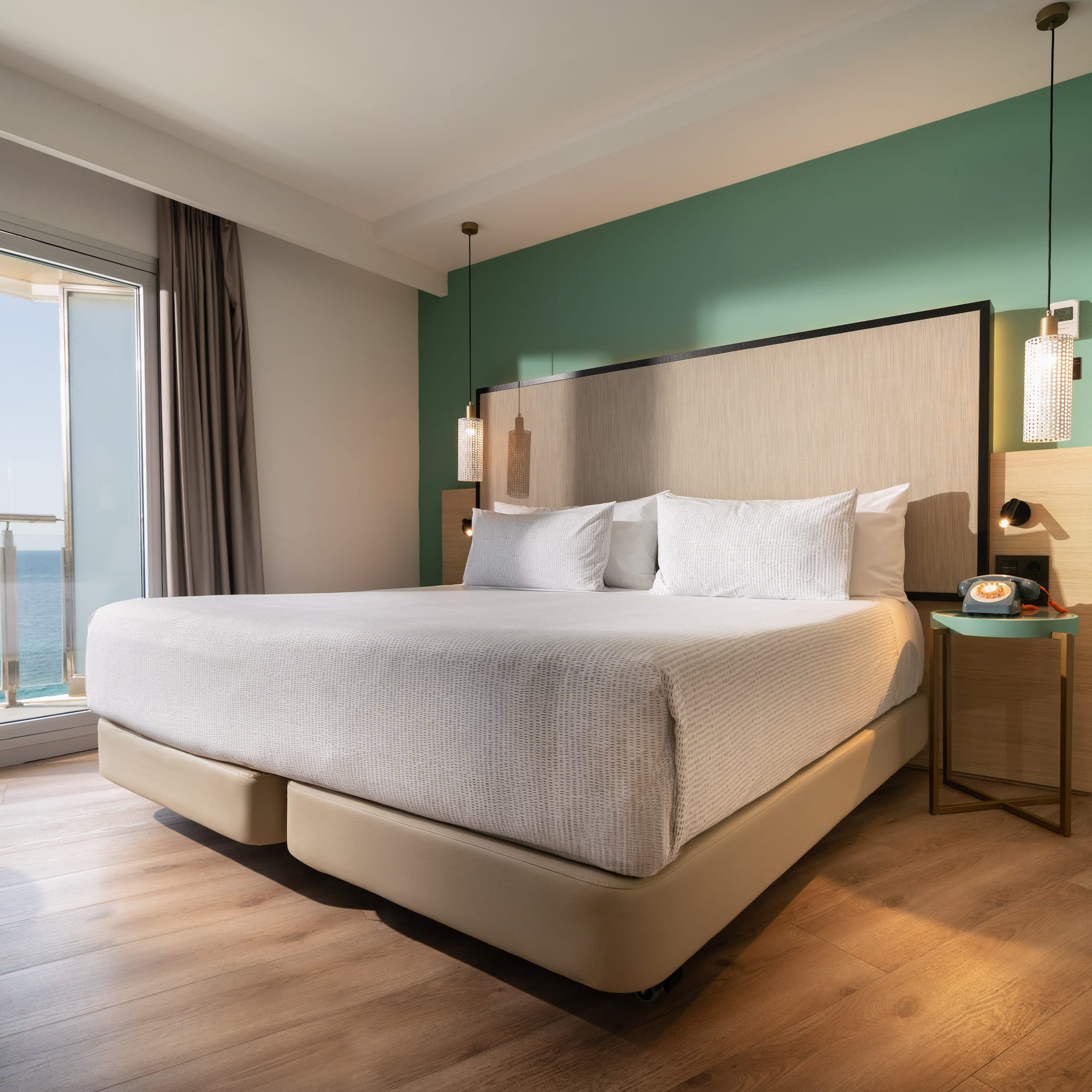 a bed with a large headboard and a glass door