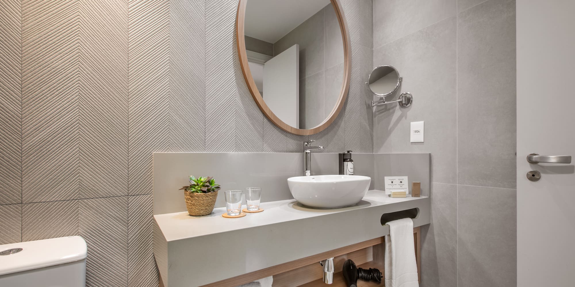 a bathroom with a round mirror and a sink