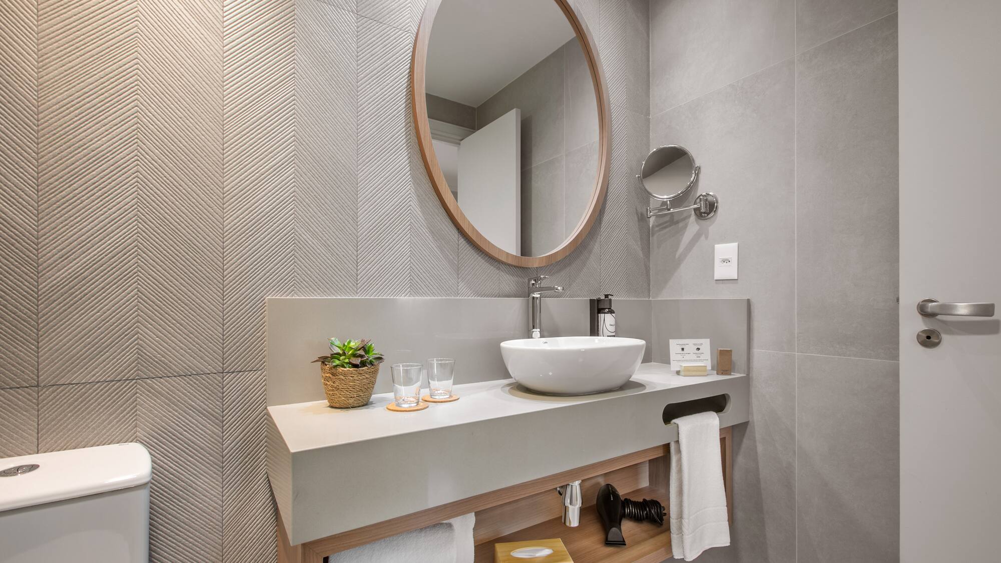 a bathroom with a round mirror and a sink