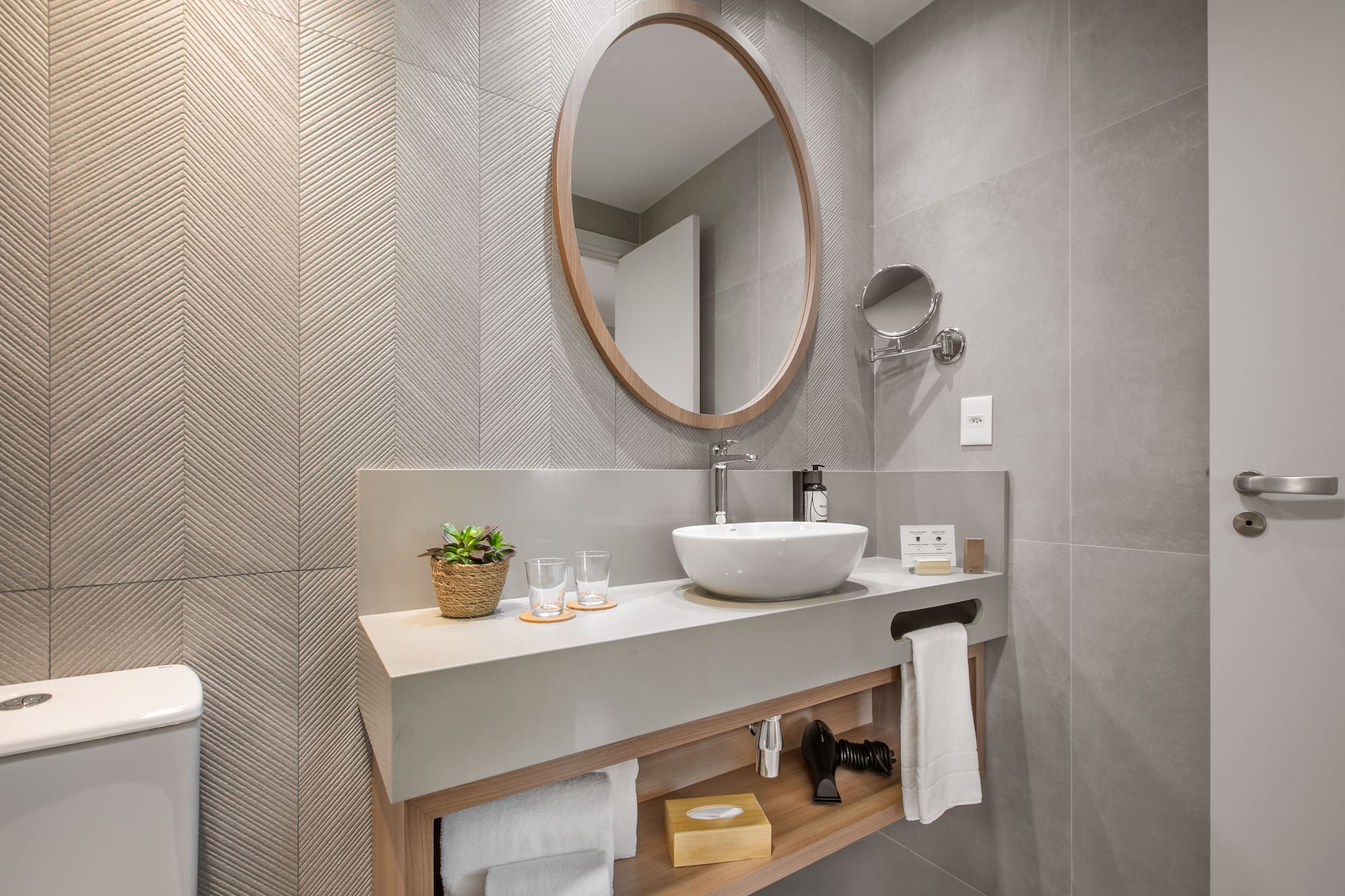 a bathroom with a round mirror and a sink