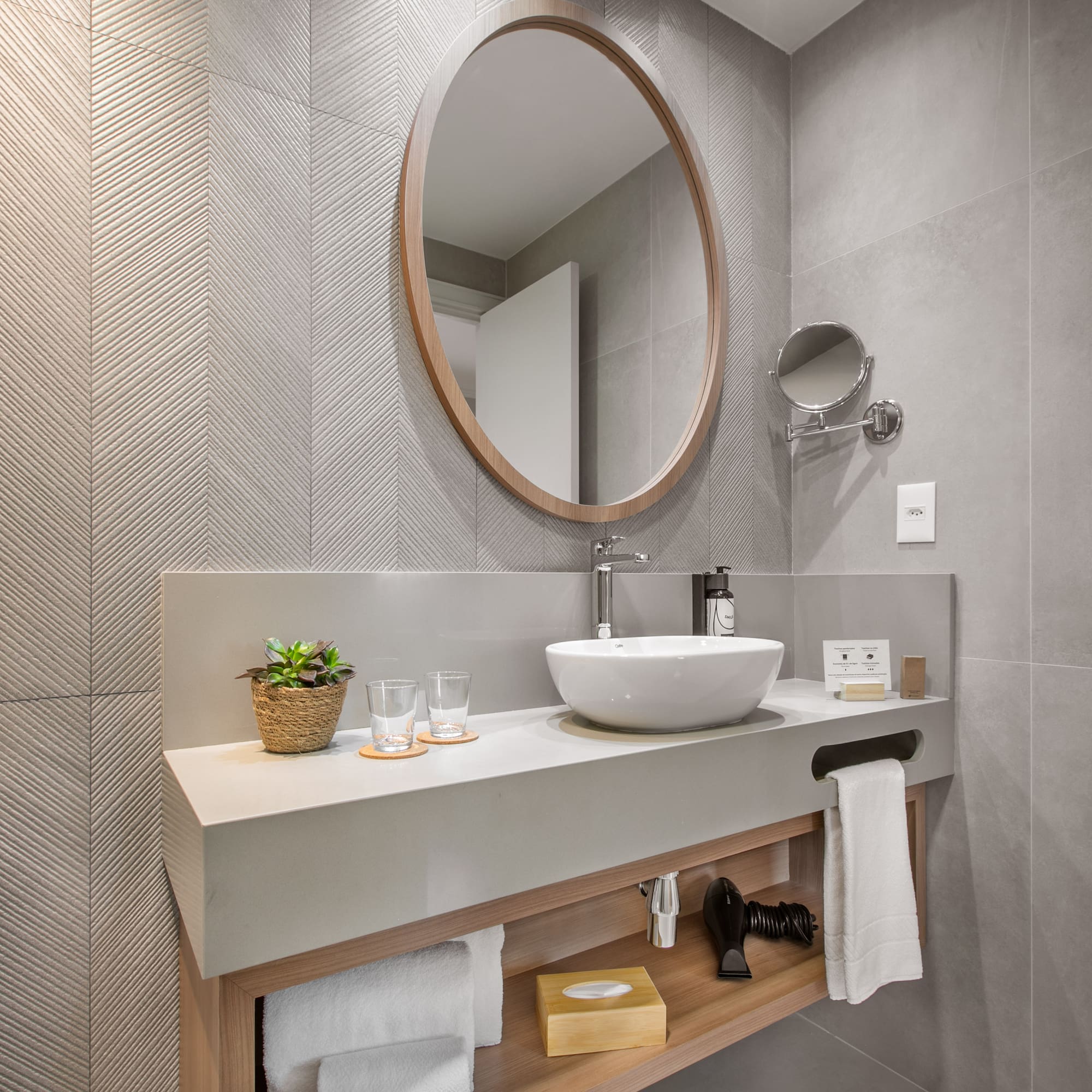 a bathroom with a round mirror and a sink
