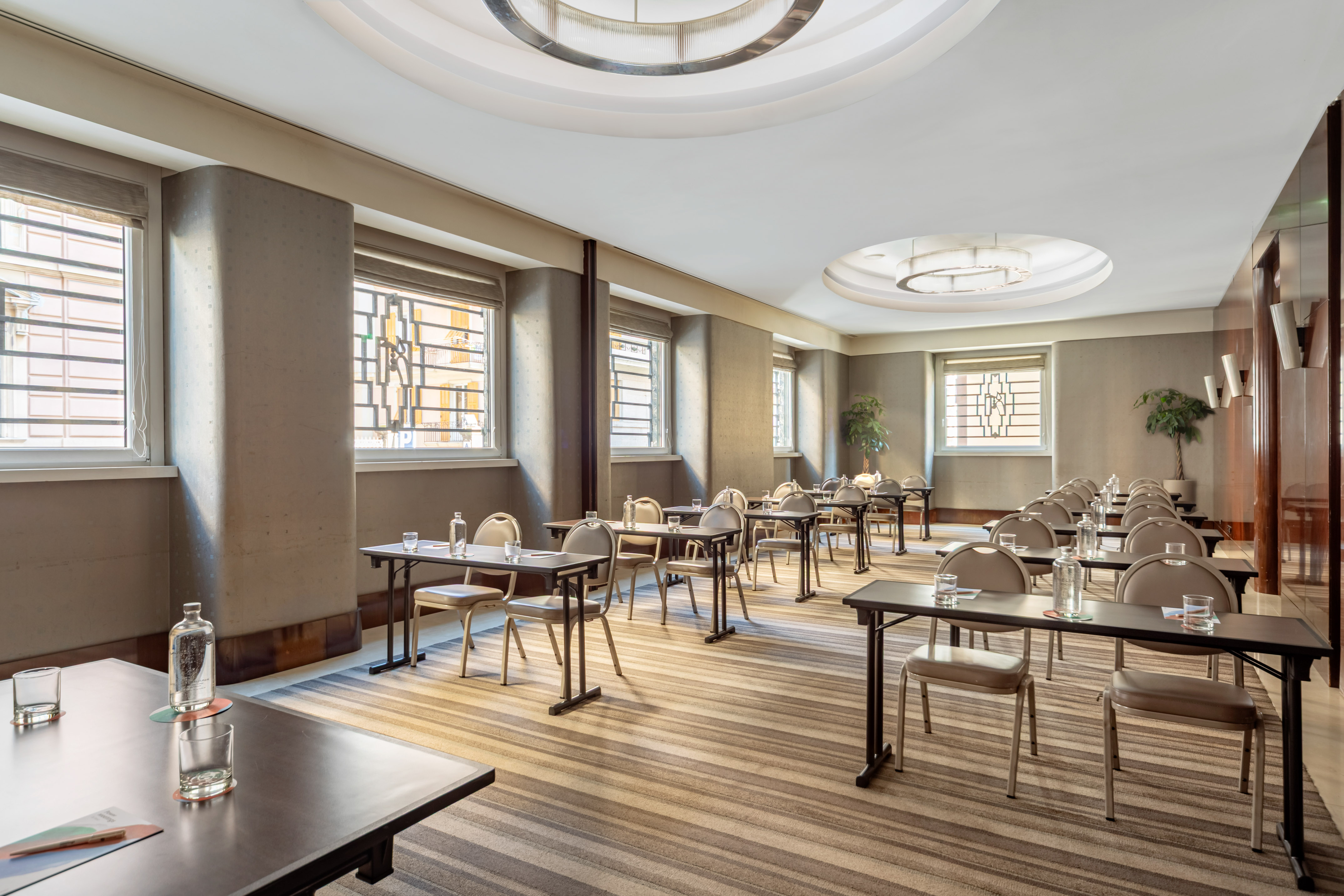 Classroom style meeting room with individual tables, chairs, natural light.