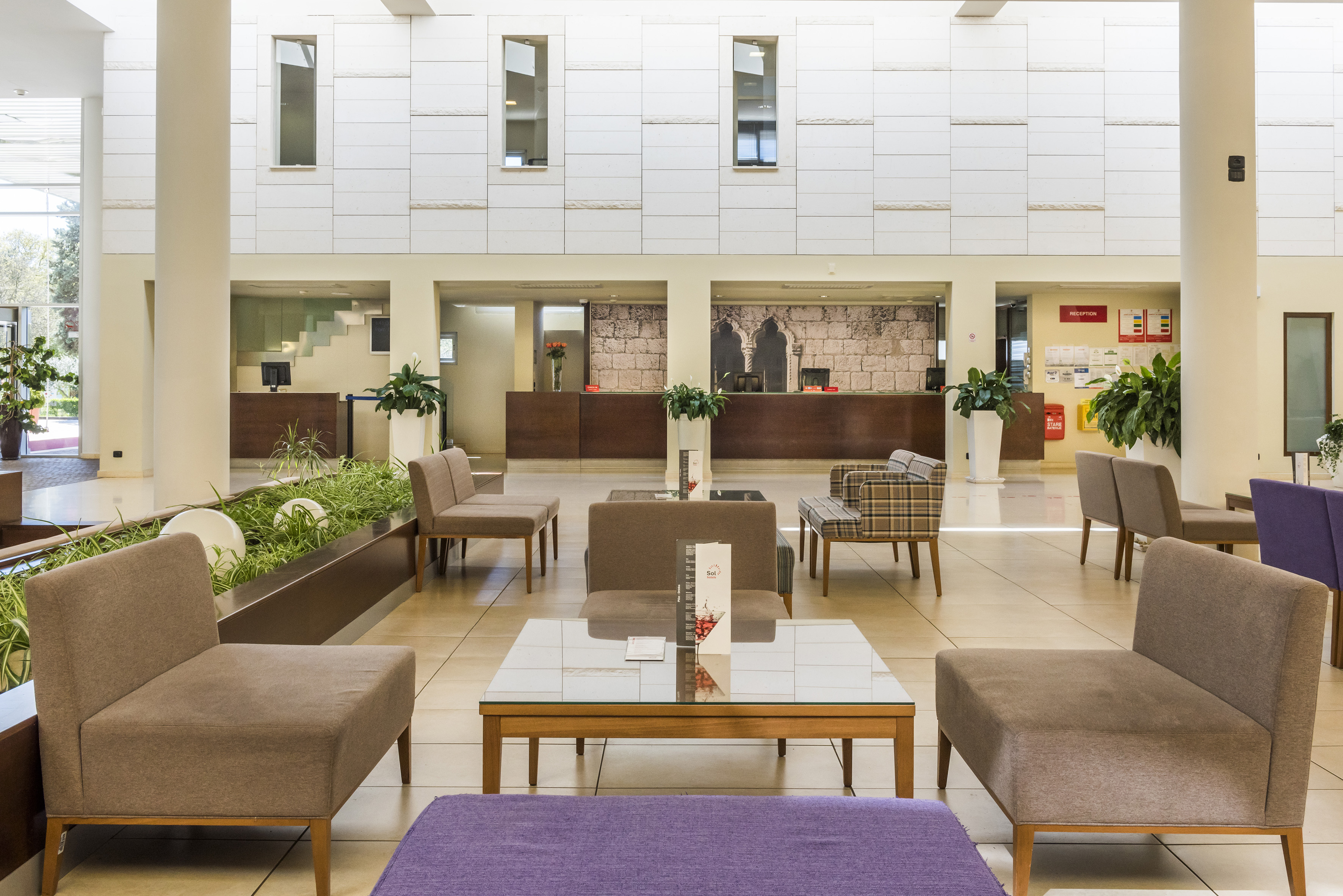 a room with a large white wall and a large window