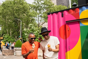 two men walking down a street with ice cream