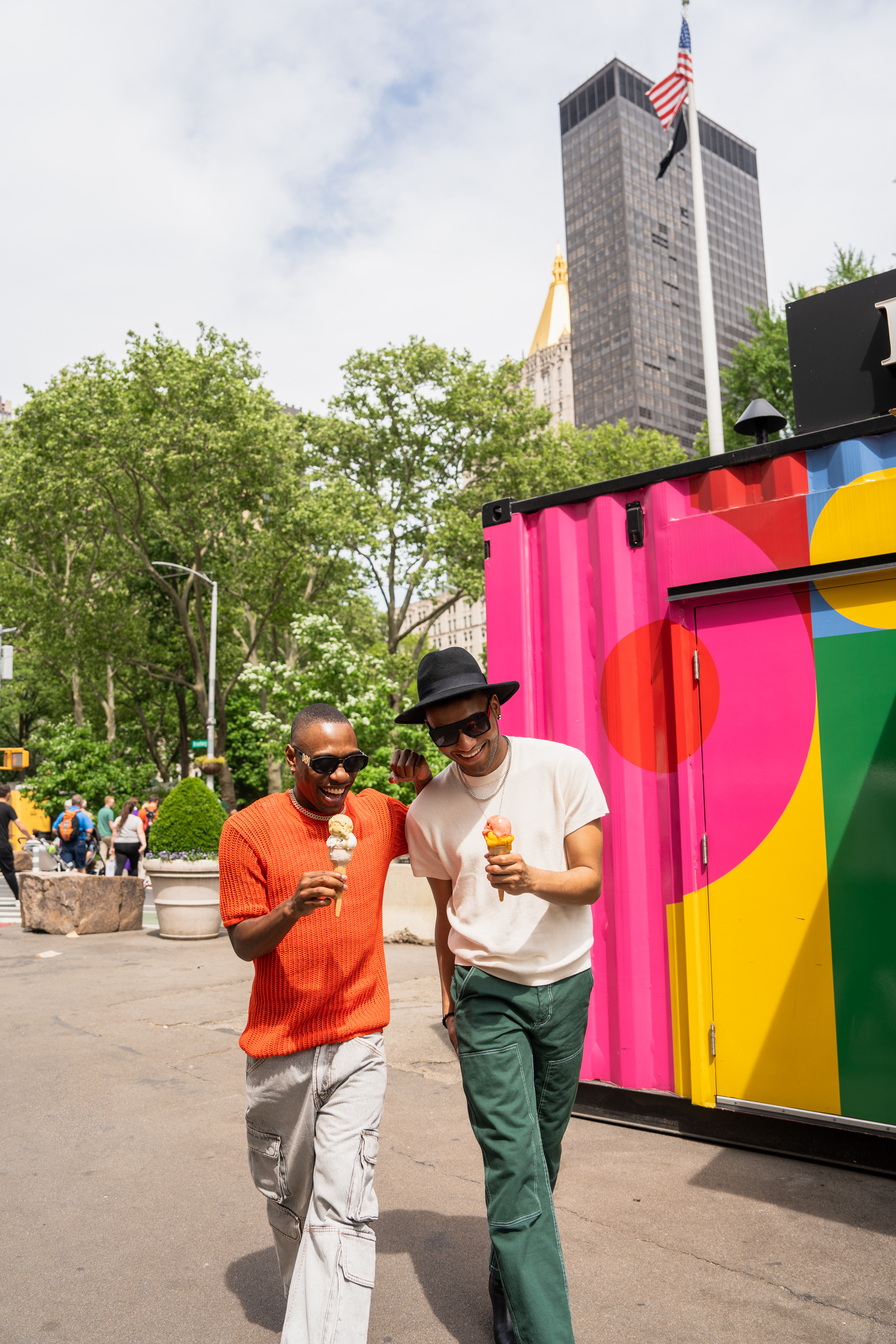two men walking down a street with ice cream