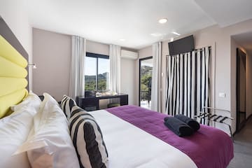a bedroom with a purple bed and black and white striped curtains