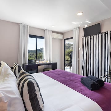 a bedroom with a purple bed and black and white striped curtains