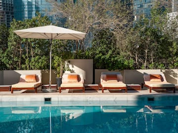 a pool with chairs and umbrella