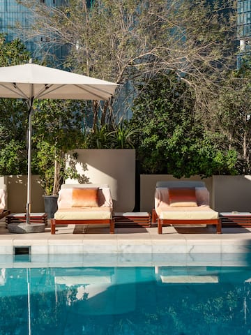 a pool with chairs and umbrella