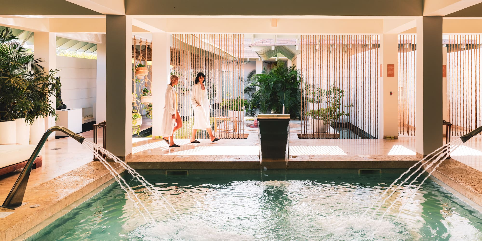 a couple of people in bathrobes standing in front of a pool