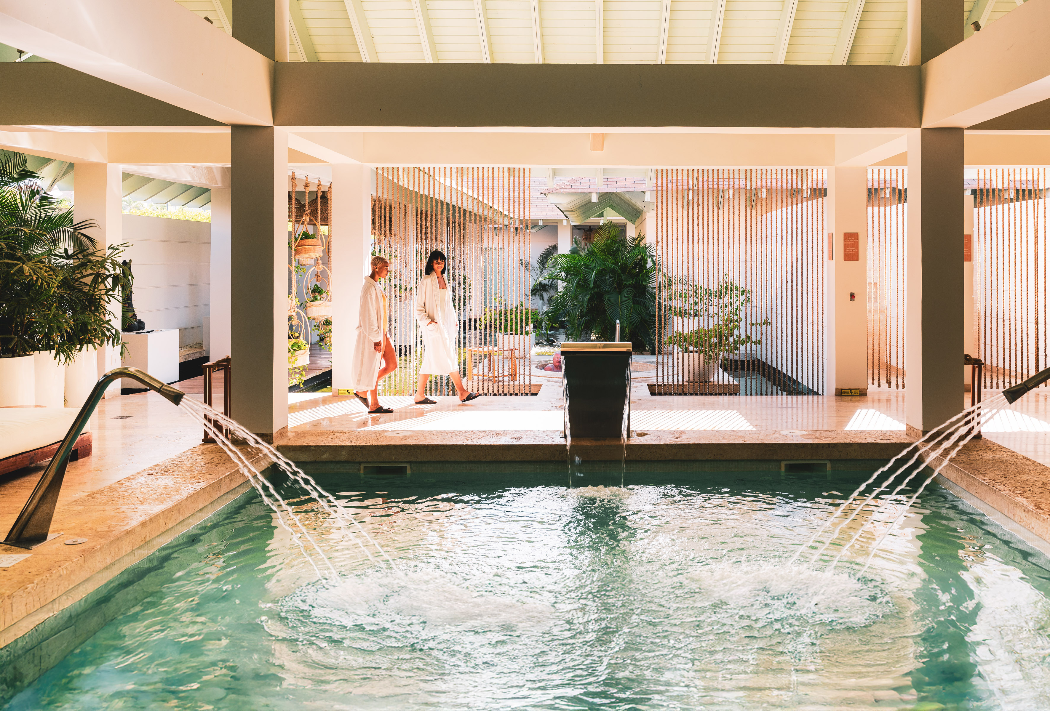 a couple of people in bathrobes standing in front of a pool