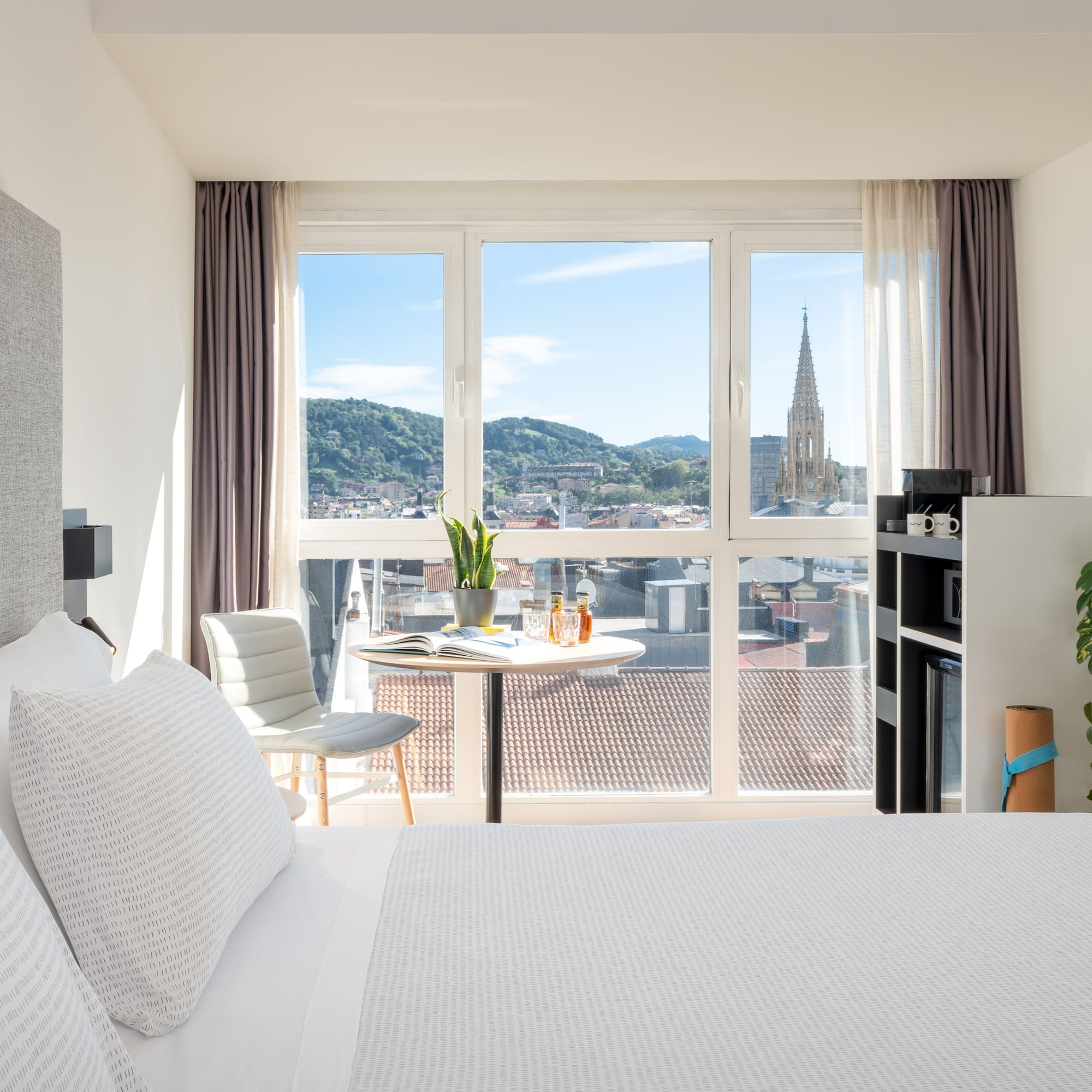 a bedroom with a table and chairs and a table with a window