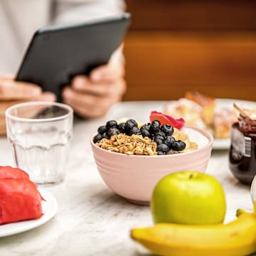 a bowl of cereal and fruits on a table