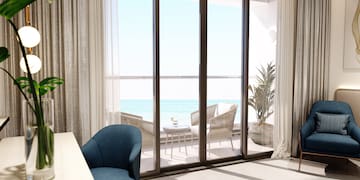 a room with a table and chairs and a table with chairs and a table with a view of the ocean