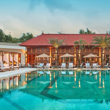 a pool with chairs and umbrellas in front of a building