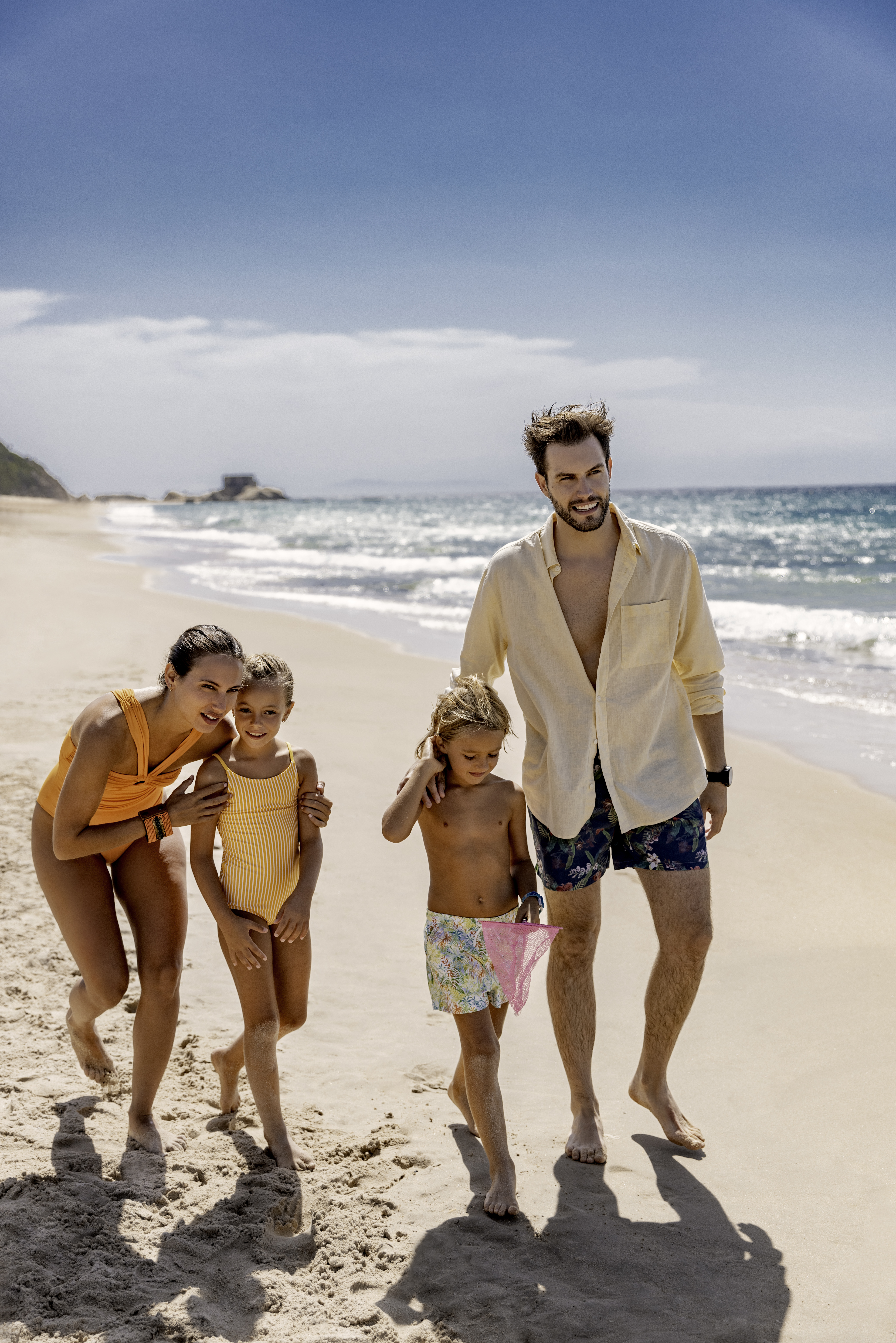 a man and woman walking on a beach with children