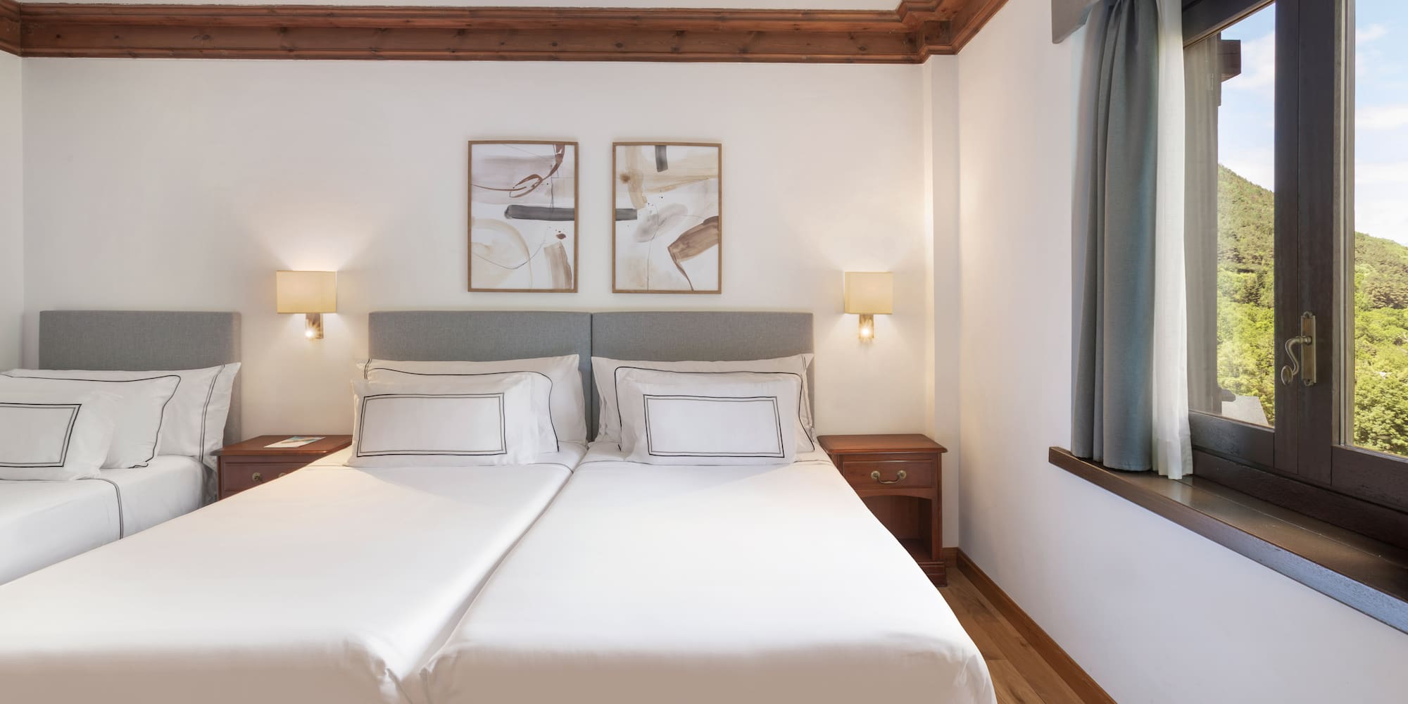 a bed with white sheets and lamps