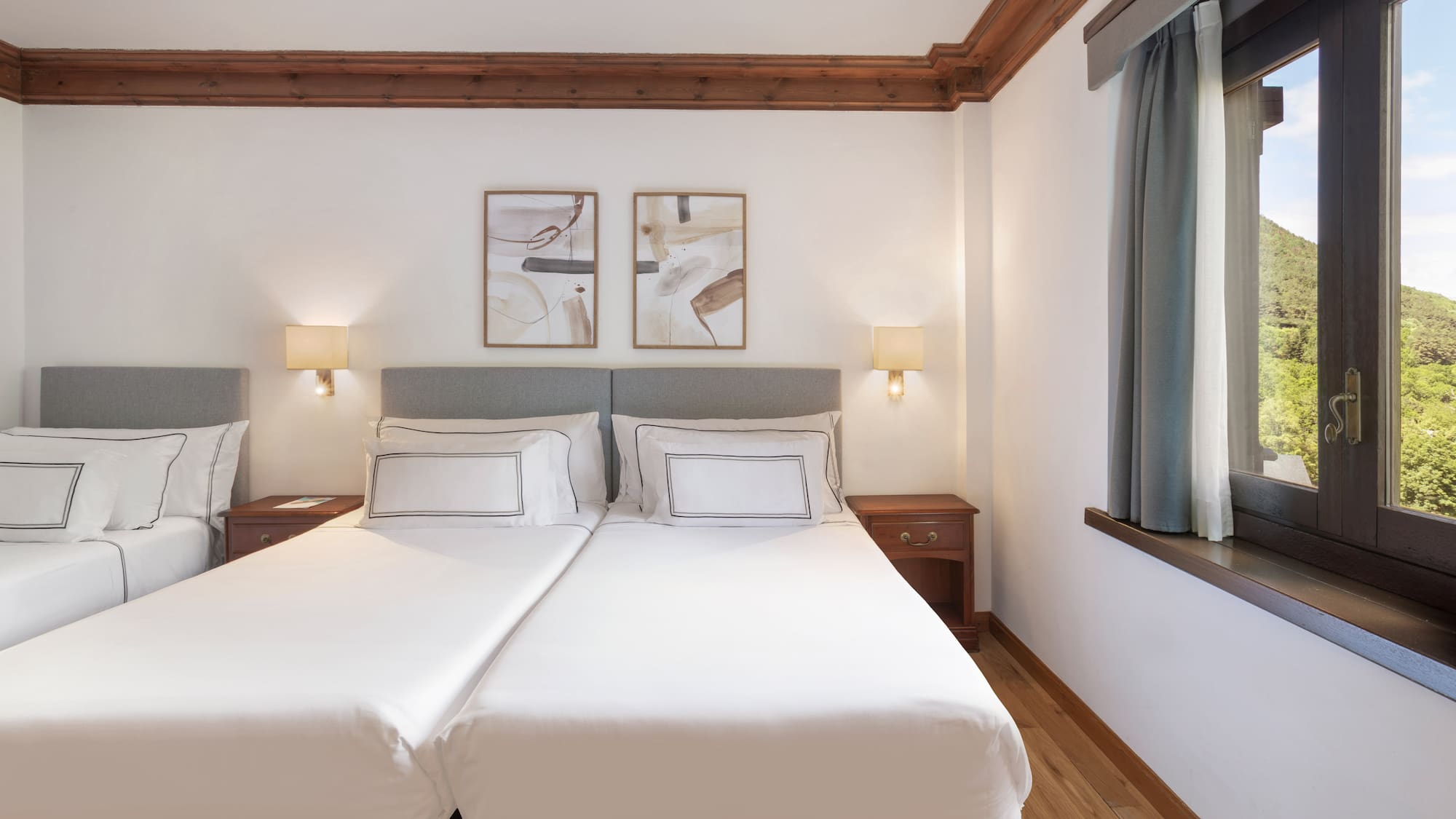 a bed with white sheets and lamps