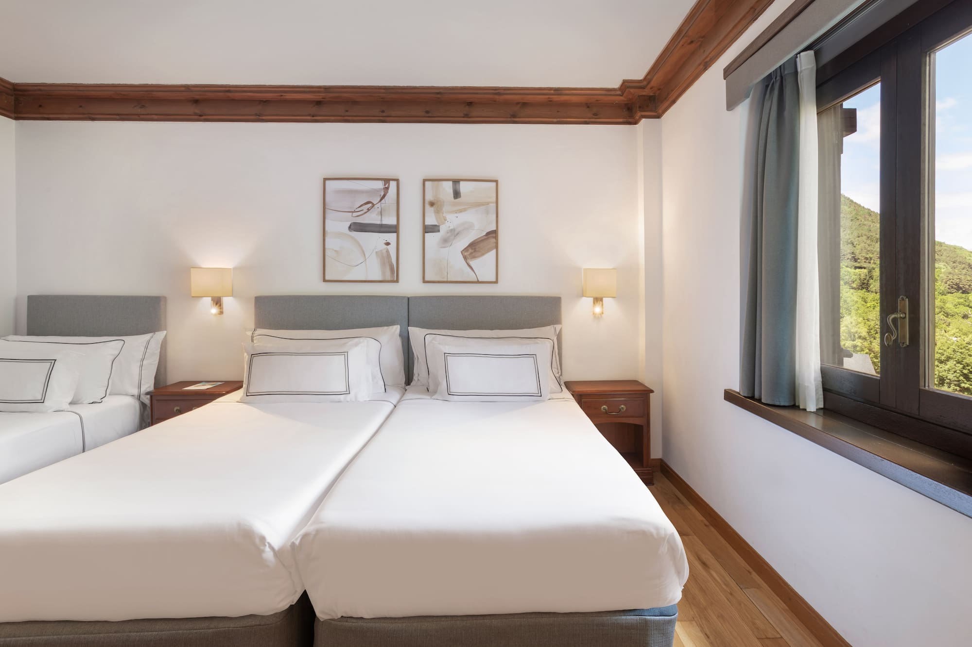 a bed with white sheets and lamps