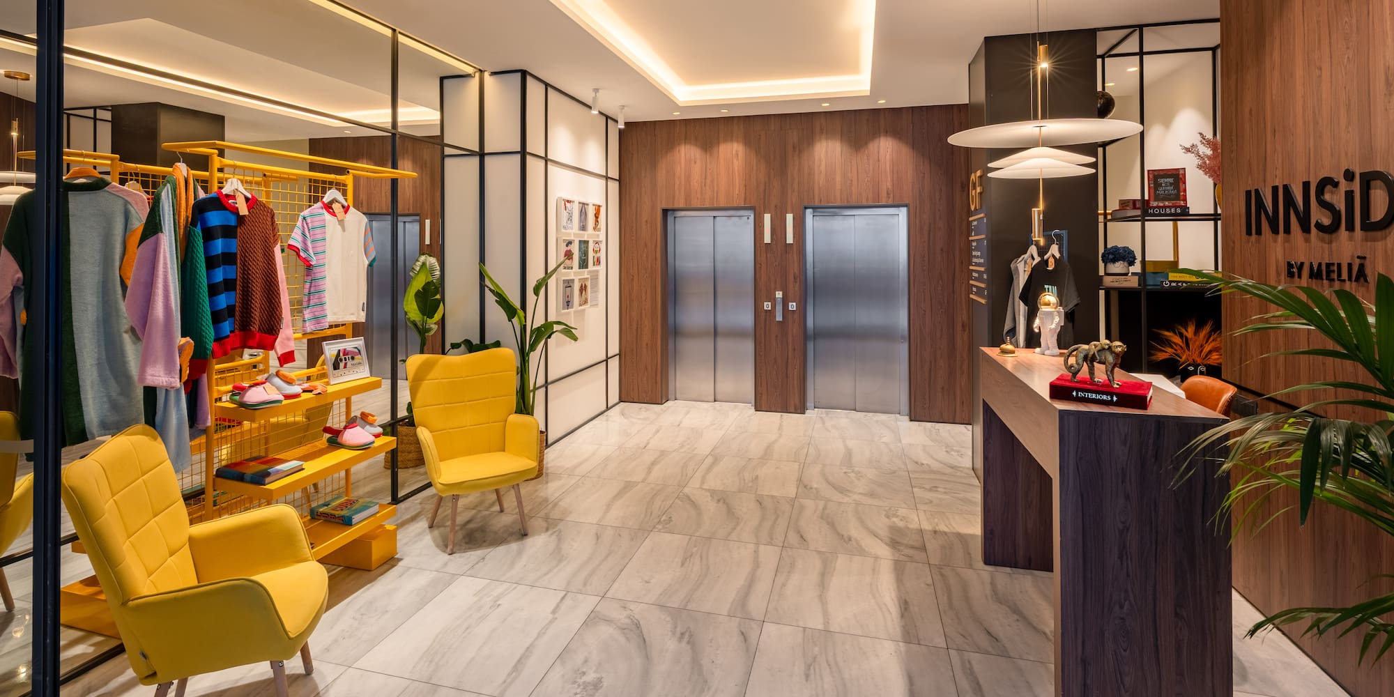 INNSiDE BY MELIÃ hotel lobby: modern reception, elevators, and colorful retail boutique.