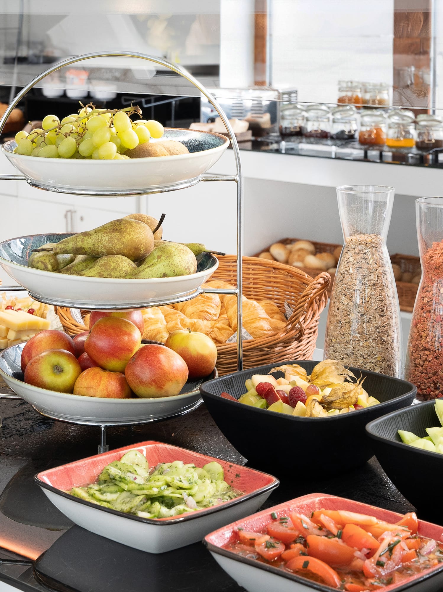 Healthy breakfast buffet featuring fresh fruit, pastries, cereals, and salads.