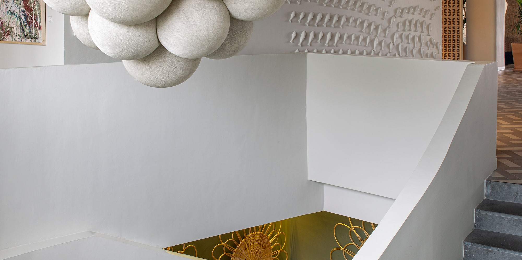 a white staircase with a large chandelier