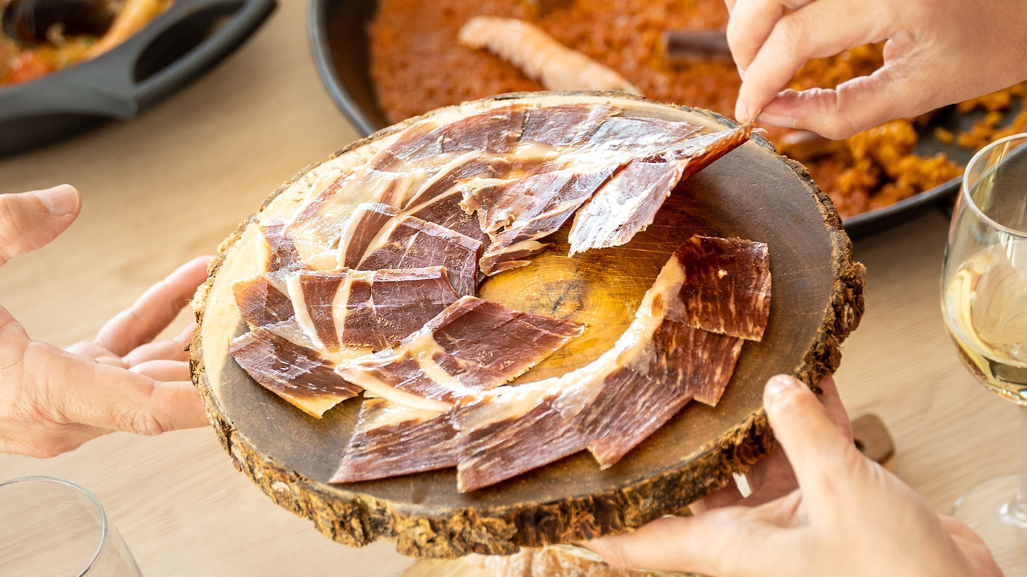 a group of hands holding a plate of meat