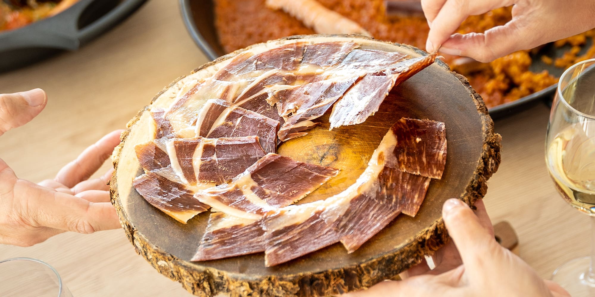 a group of hands holding a plate of meat