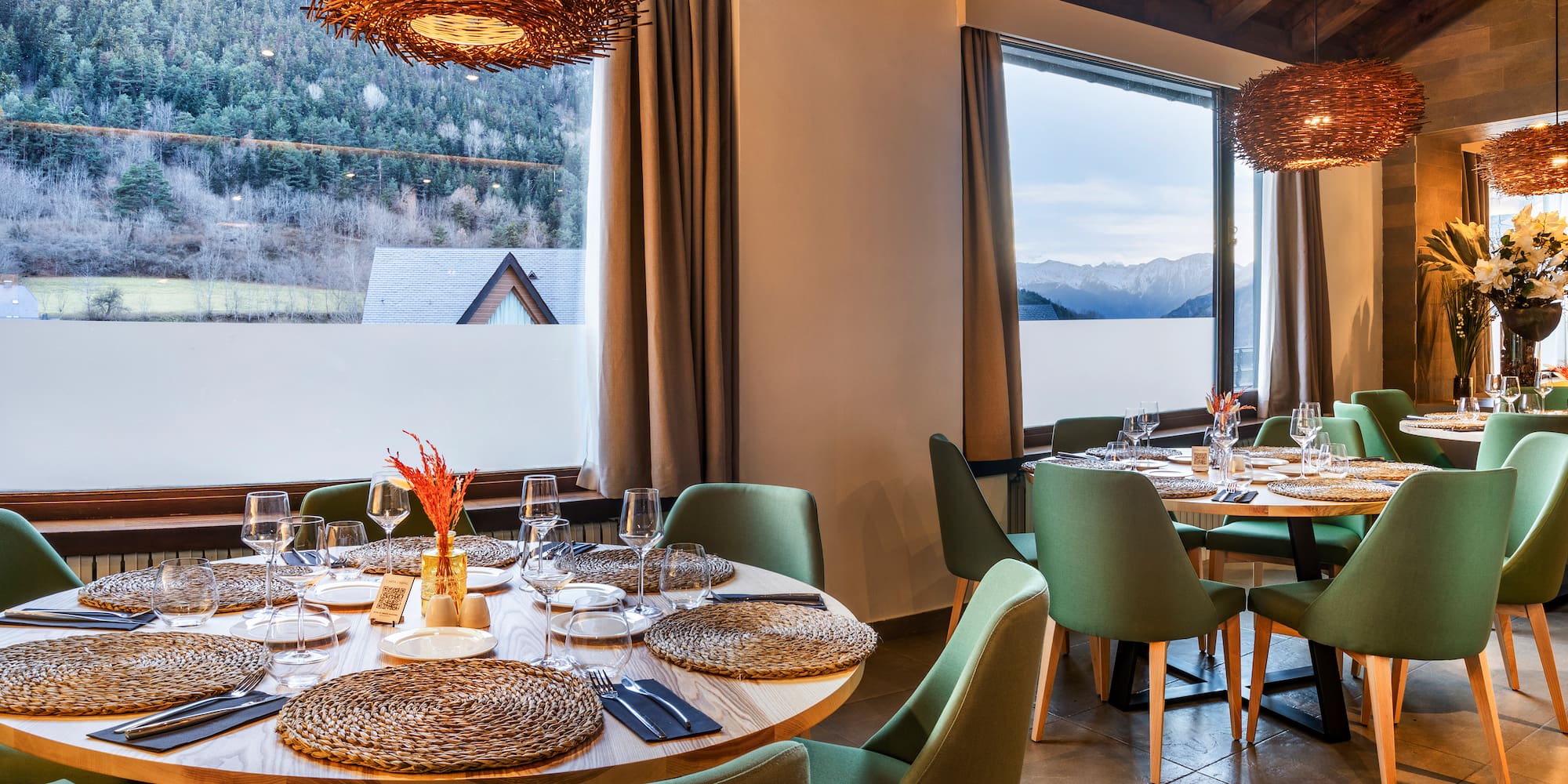 a room with a table set up and chairs and a large window