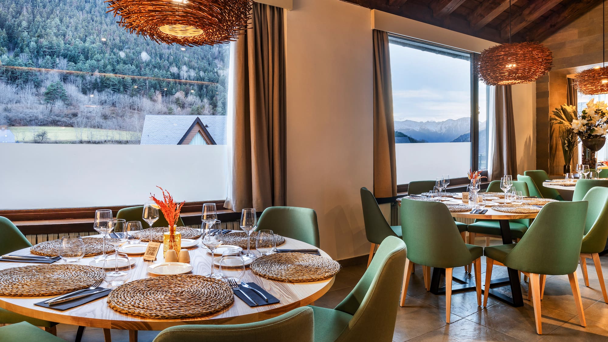 a room with a table set up and chairs and a large window