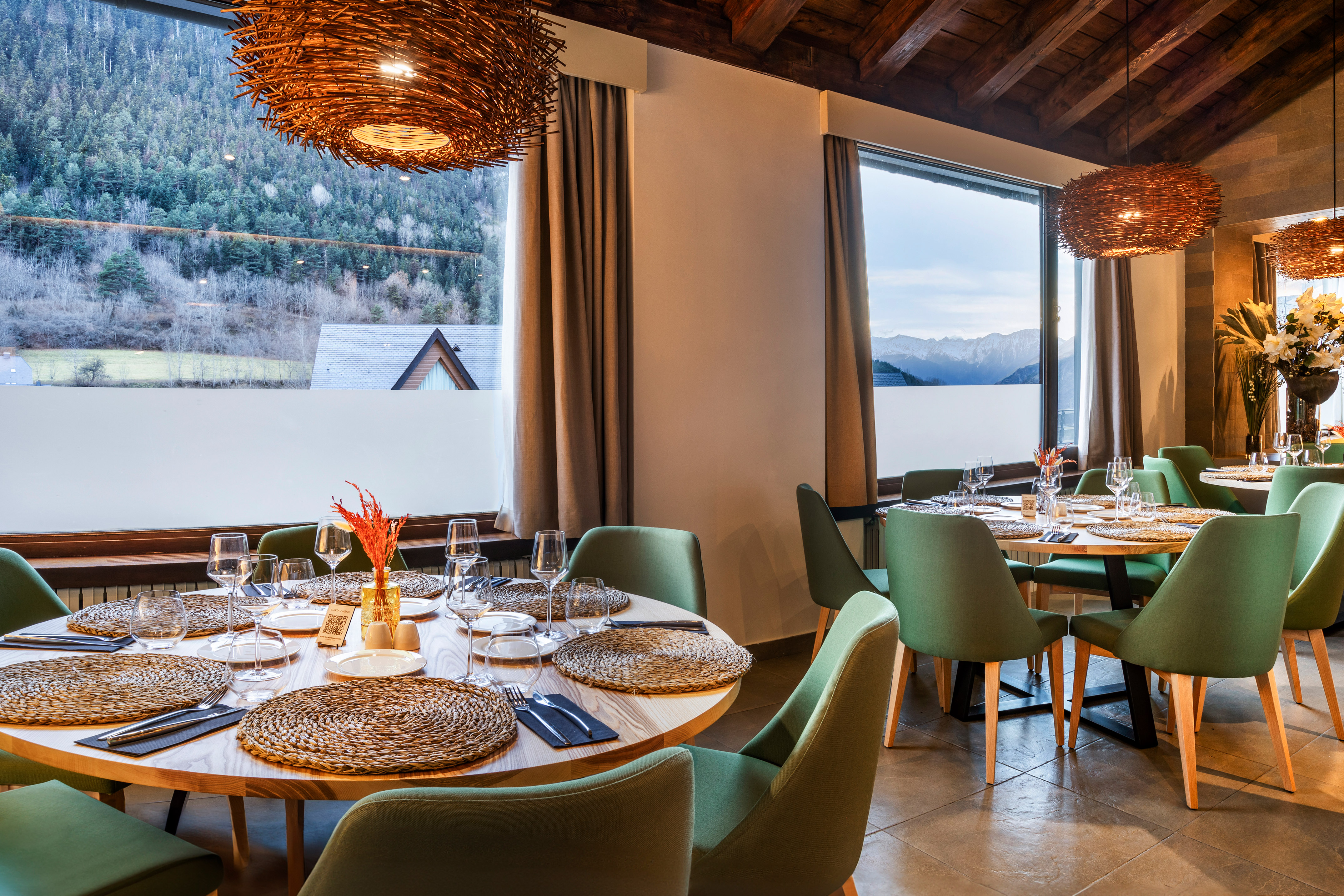 Mountain view restaurant dining room with green chairs and natural decor.