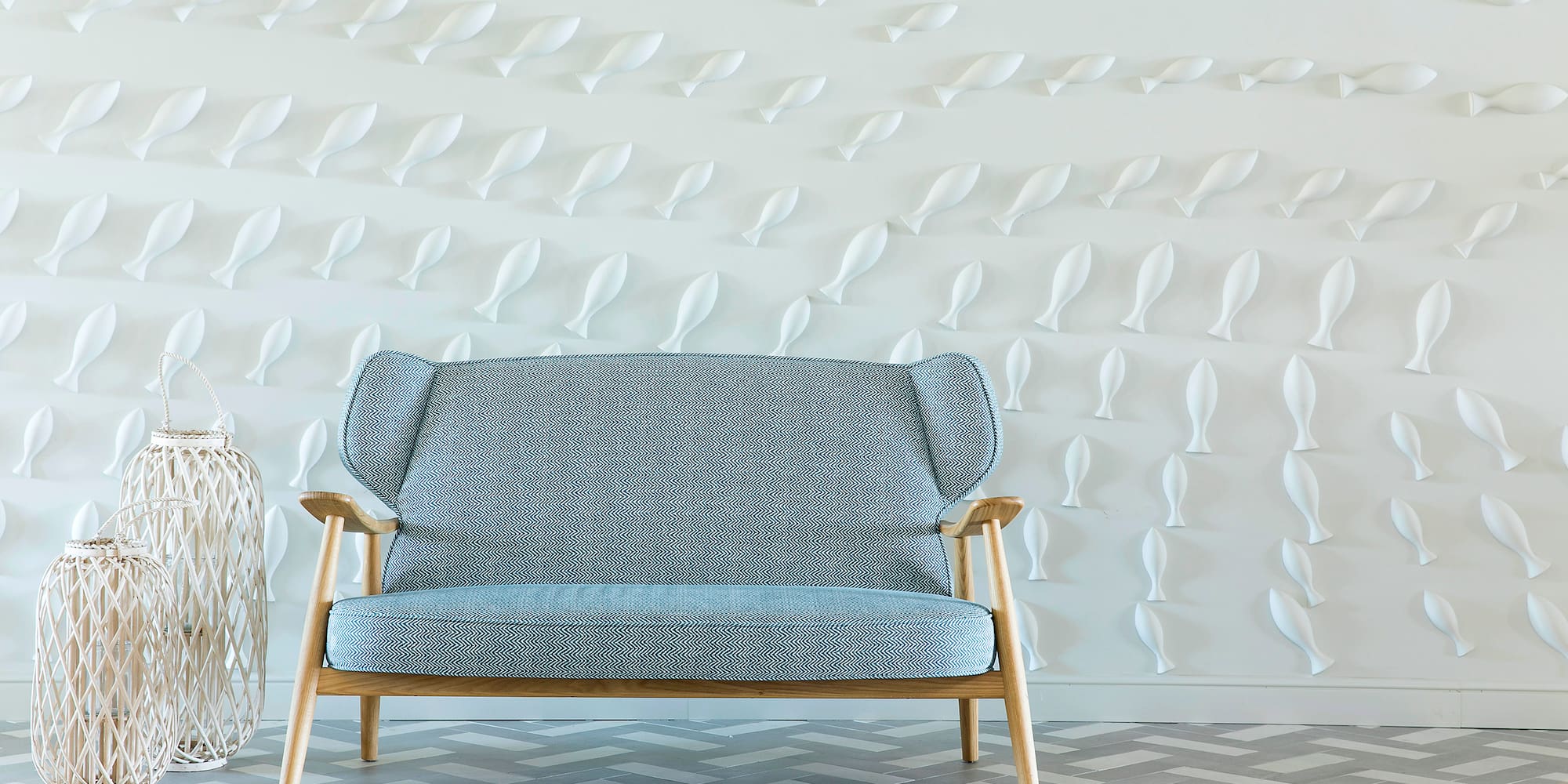 a blue and white couch in front of a white wall