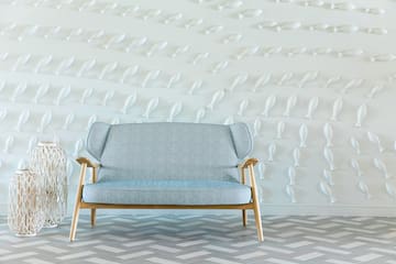 a blue and white couch in front of a white wall