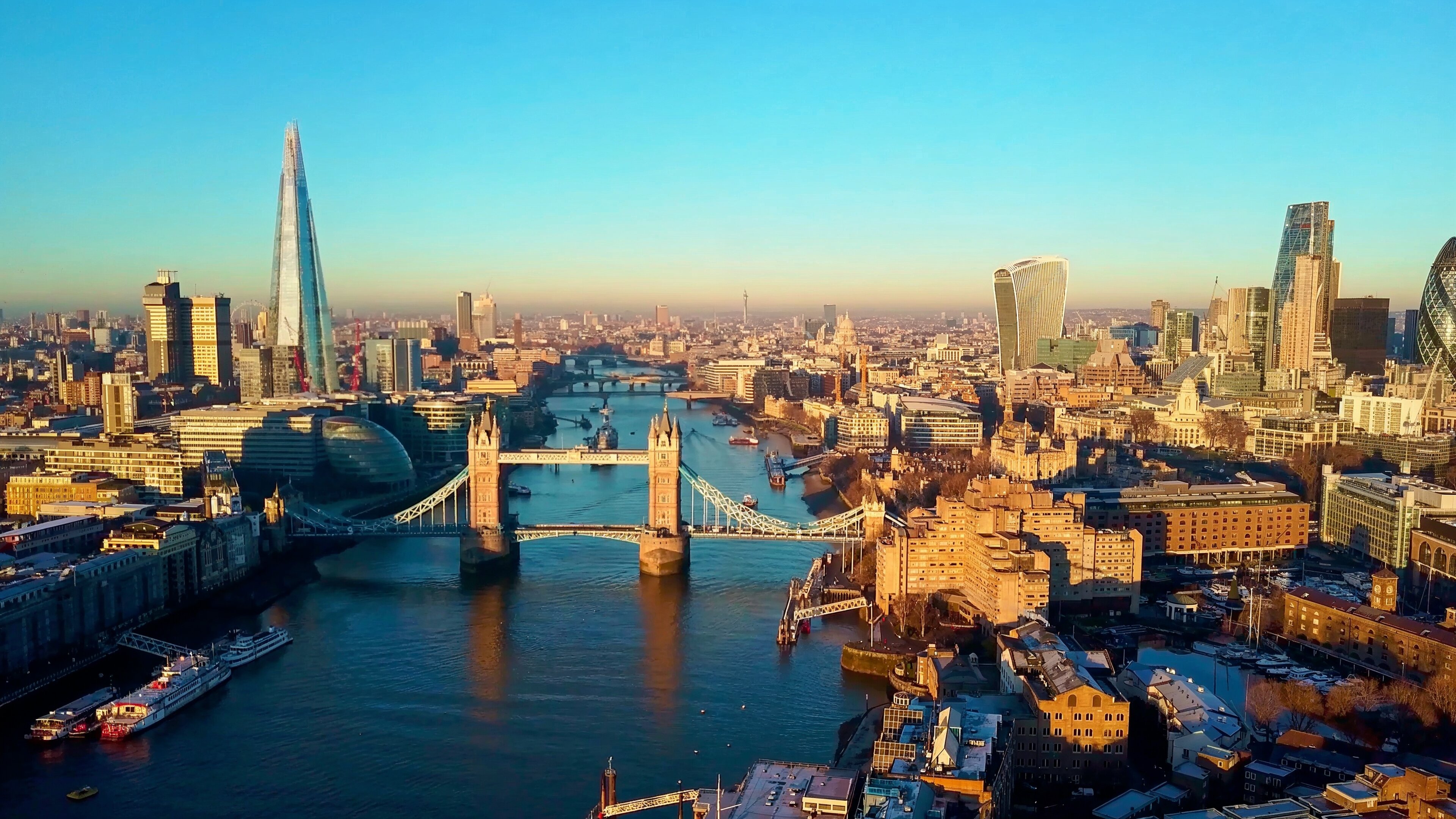 a bridge over a river with a city in the background