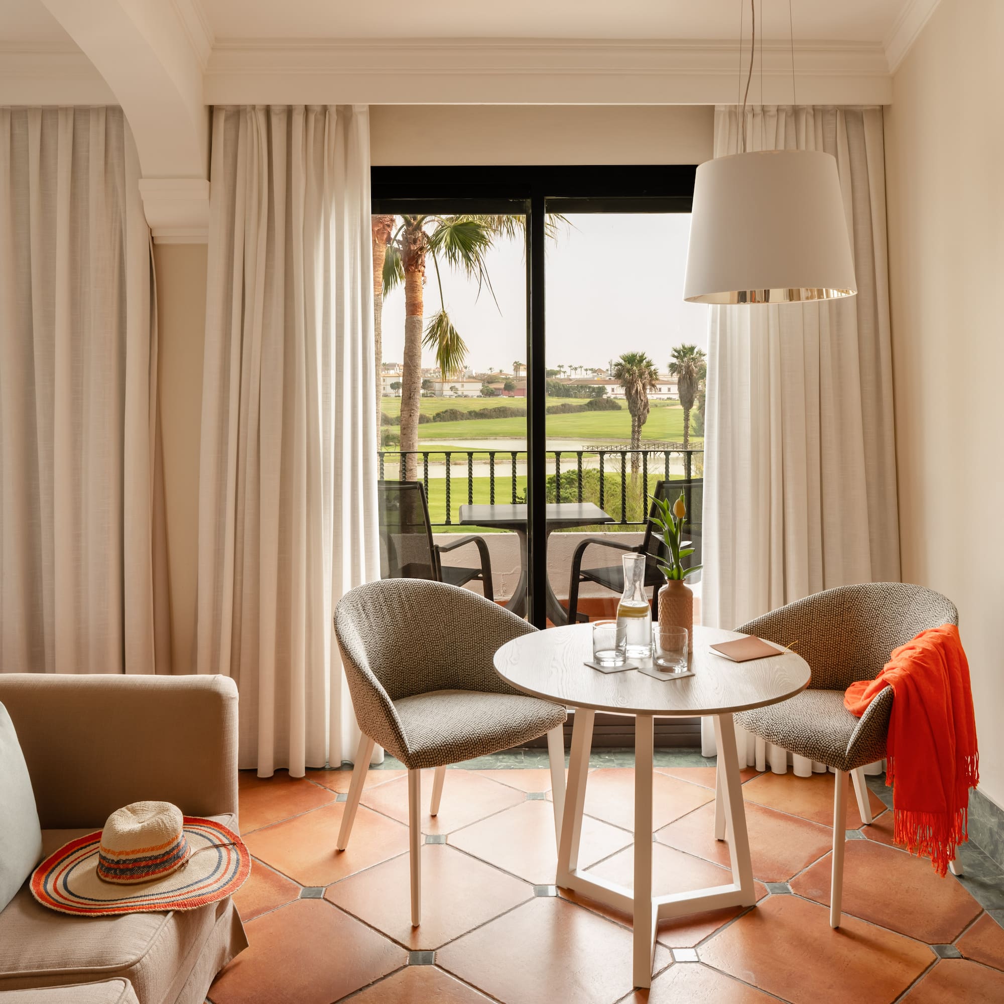 a room with a table and chairs and a chair and a table with a hat