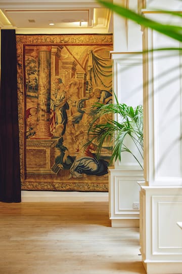 a room with a tapestry and a plant