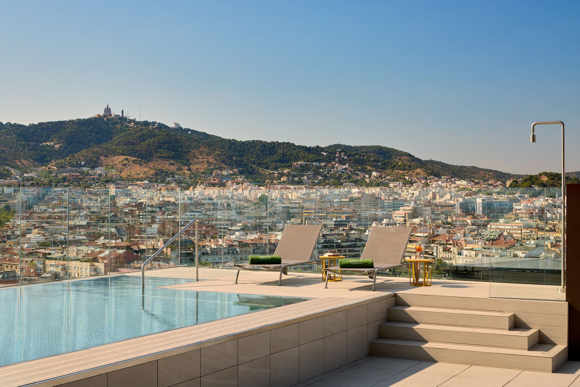 Piscina en azotea de hotel con vistas a Barcelona y el Tibidabo.