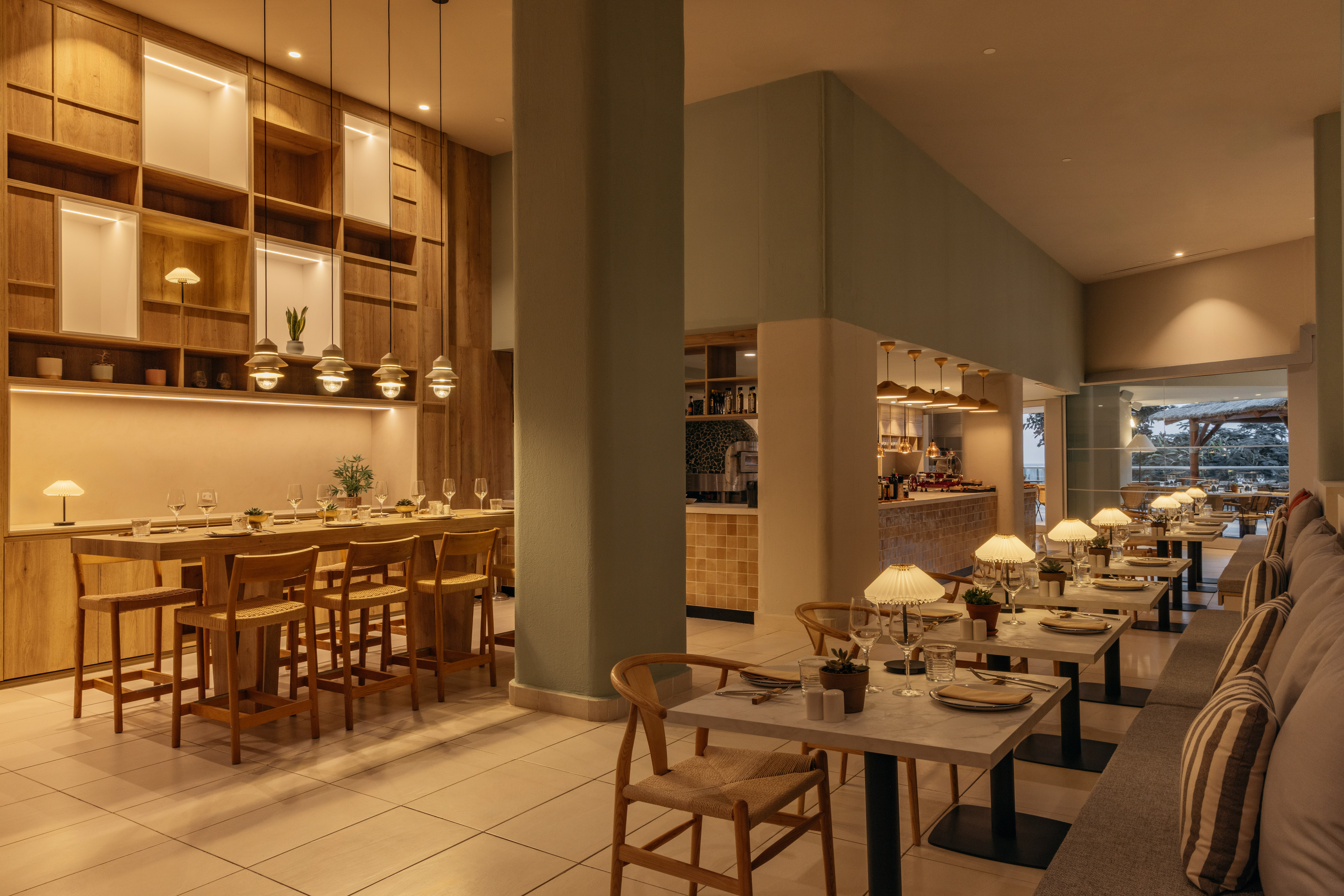 Modern restaurant dining room with wooden communal table and elegant seating.