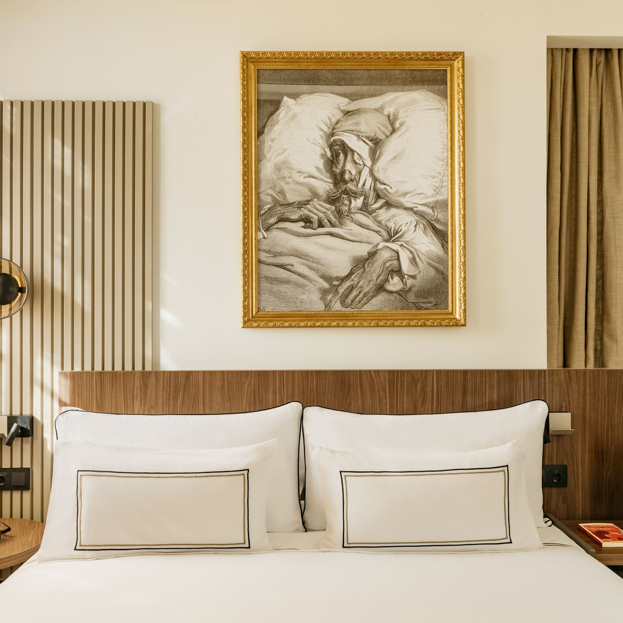 a bed with a painting on the wall